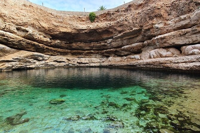 Full Day Group Tour to Wadi Shab Bimmah Sinkhole and Fins Beach - Fins Beach: white stones and blue water